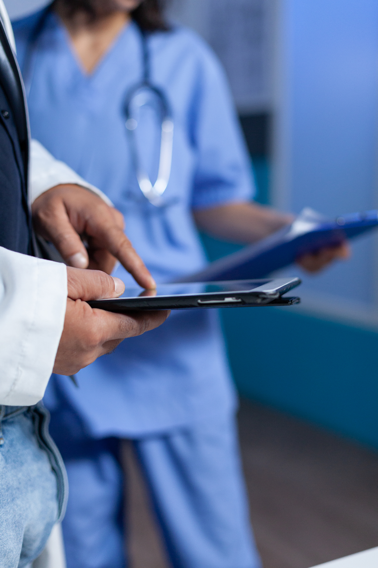 Médico Promed conduzindo avaliação em tablet durante passagem de plantão hospitalar